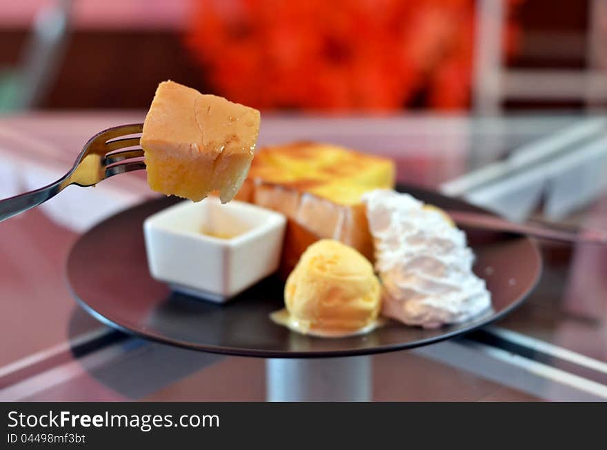 Close up toast  on fork , toast and whipping cream with vanilla ice cream  served with honey sauce. Close up toast  on fork , toast and whipping cream with vanilla ice cream  served with honey sauce