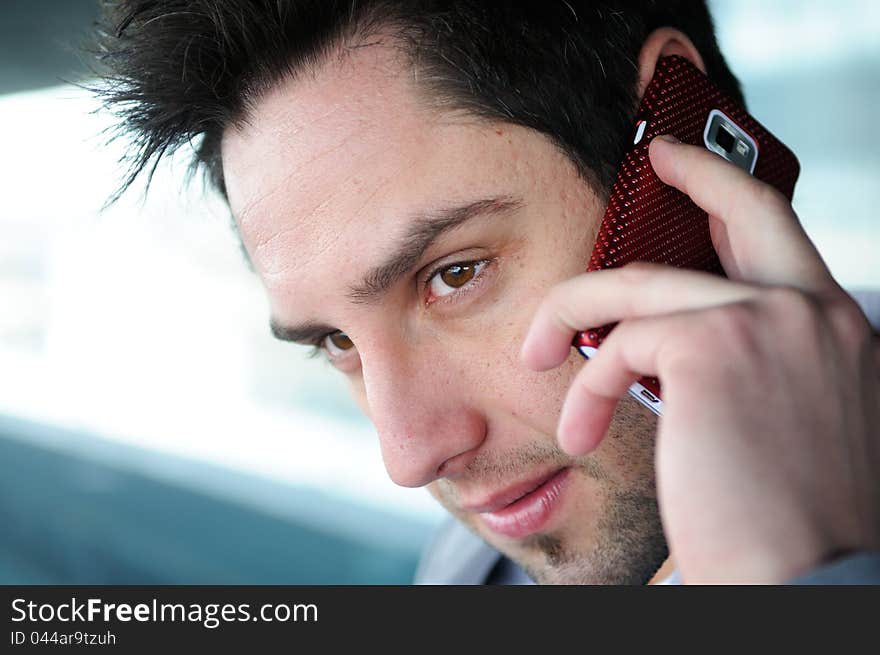 Portrait of handsome man in urban background talking on phone. Portrait of handsome man in urban background talking on phone