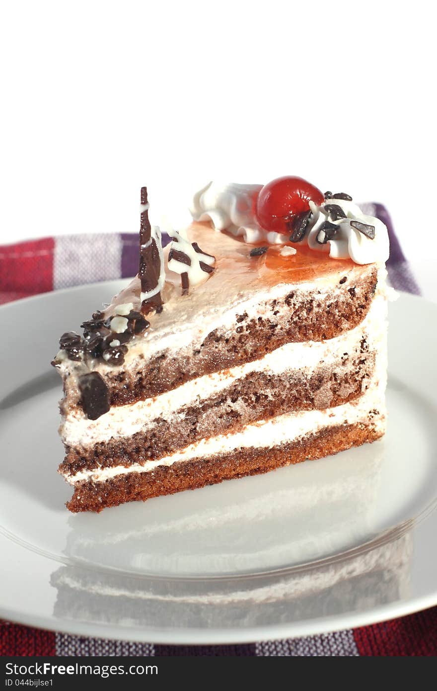 Chocolate pie with a cherry on a white plate