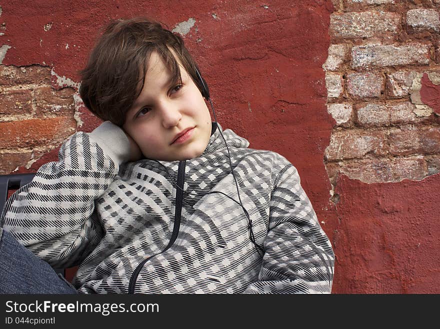 A young boy listening to music through his headphones. A young boy listening to music through his headphones.