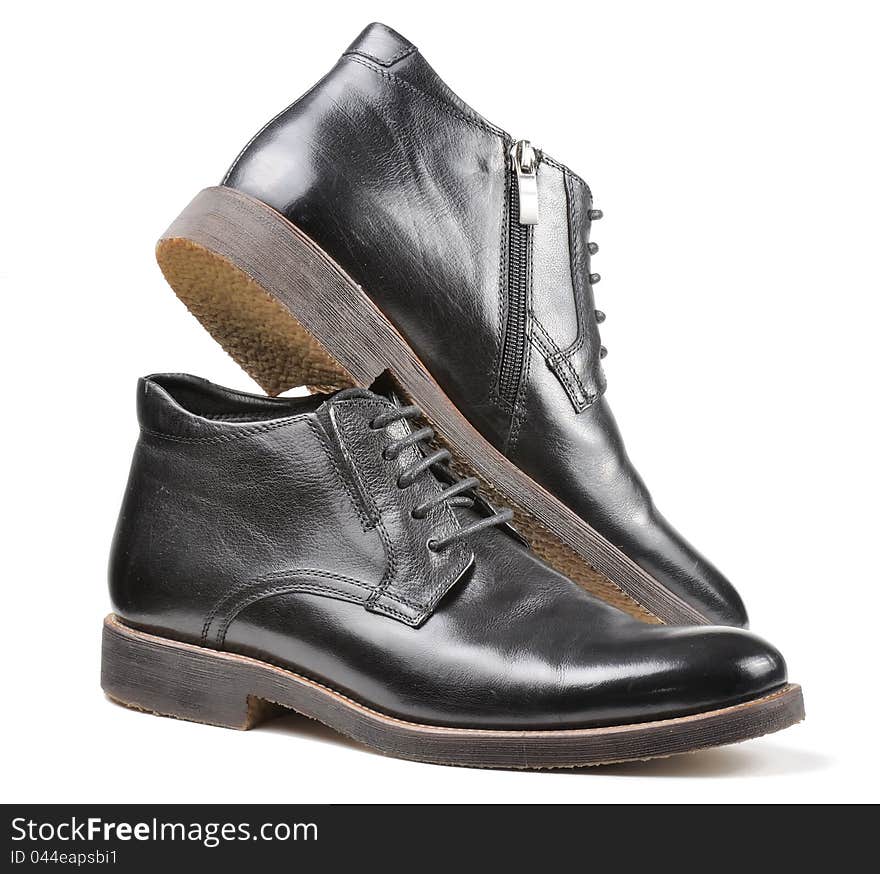 A pair of men's classic black leather winter shoes against a white background. A pair of men's classic black leather winter shoes against a white background