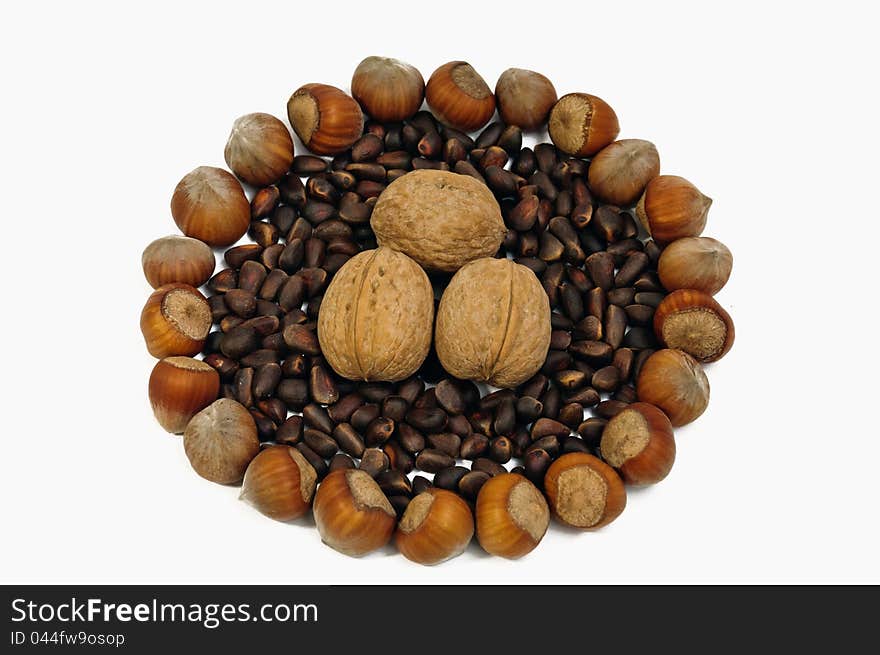 Handful of fresh hazelnuts filled up among the pine nuts, isolated on white background. Handful of fresh hazelnuts filled up among the pine nuts, isolated on white background