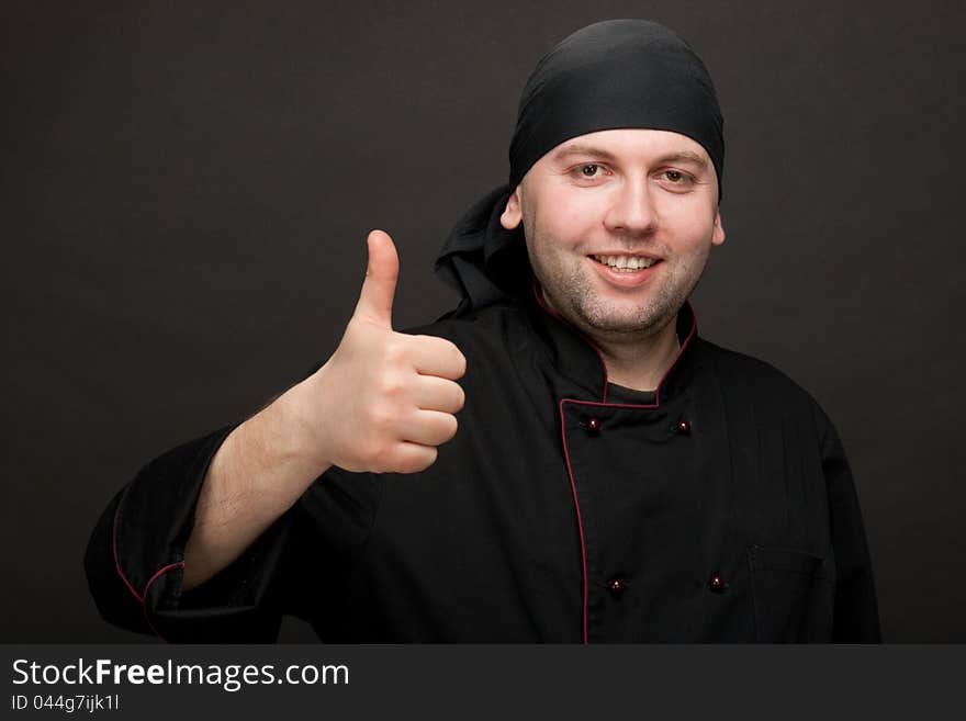 Professional chef in black uniforms showing thumbs up. Professional chef in black uniforms showing thumbs up