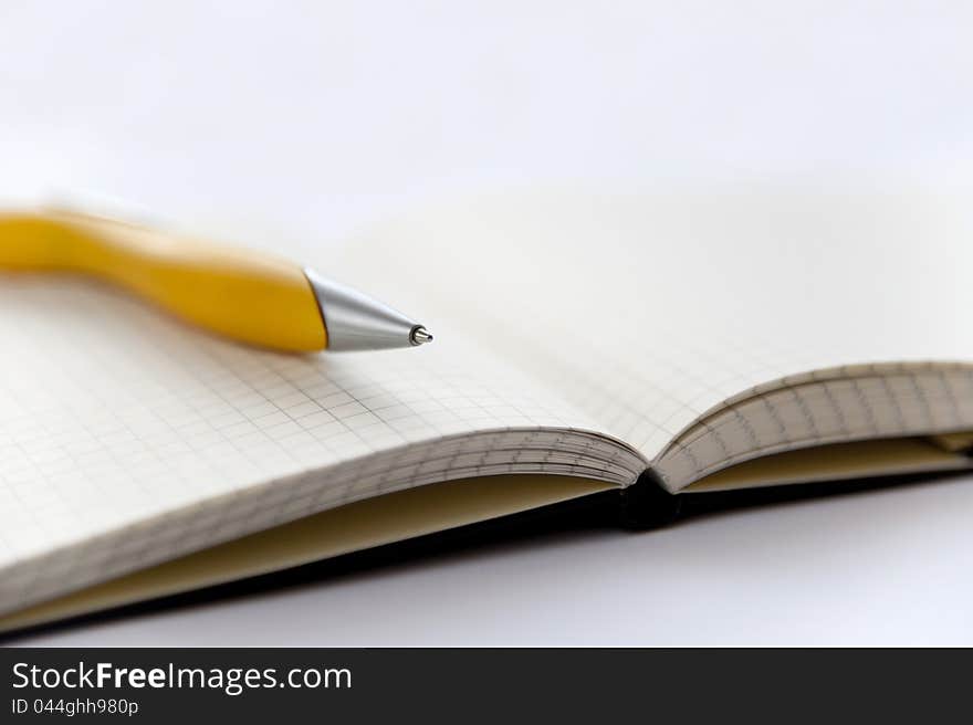 Yellow pen and notebook on the white background