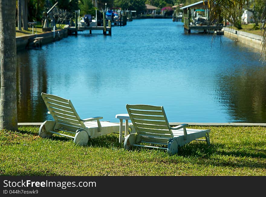 Two Empty Chairs By The Water