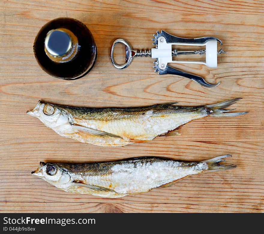 Dry salty fish and beer on a wooden background