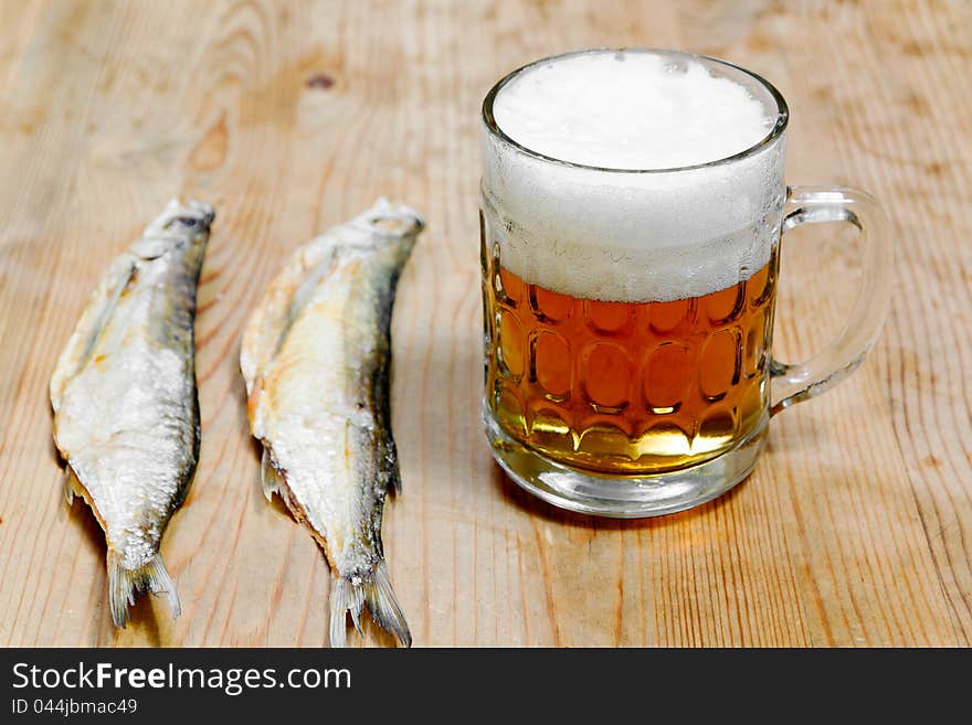 Dry salty fish and beer on a wooden background