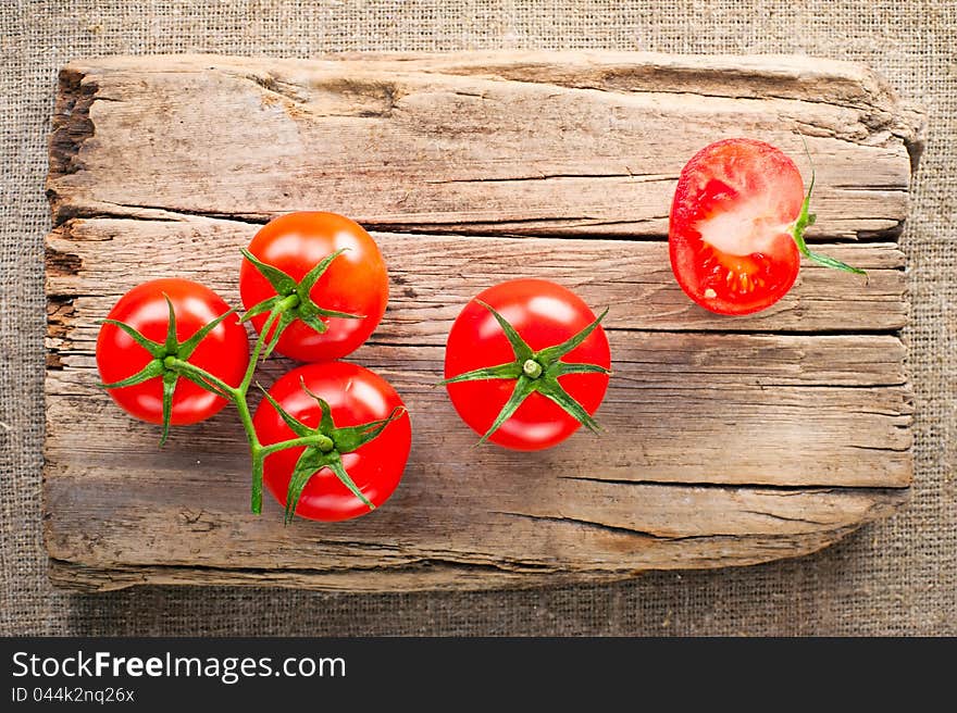 Fresh tomatoes on vintage wooden cutting board and linen background. Fresh tomatoes on vintage wooden cutting board and linen background