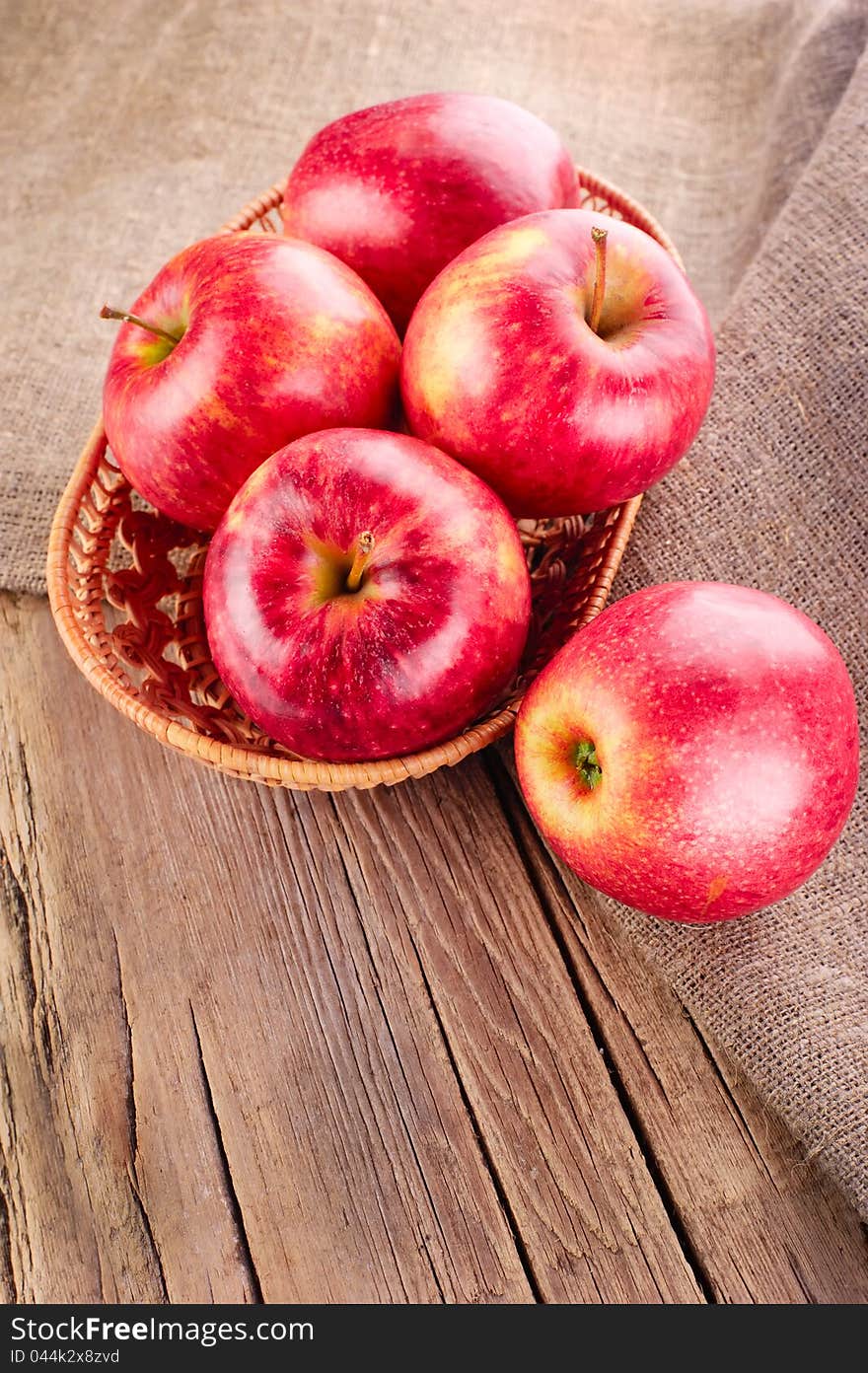 Ripe apple fruits on old wooden table with canvas tablecloth