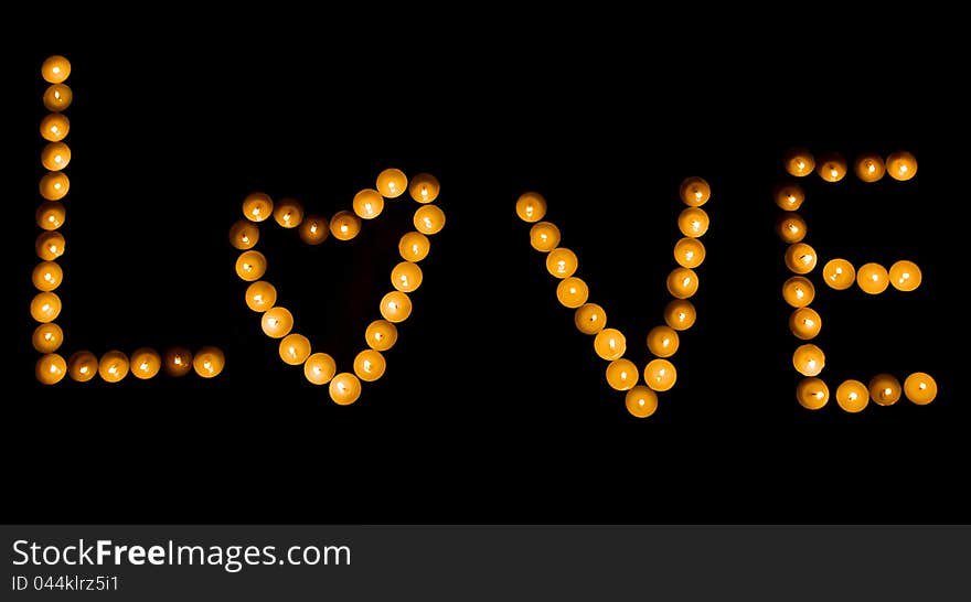 The word love is lined with candles