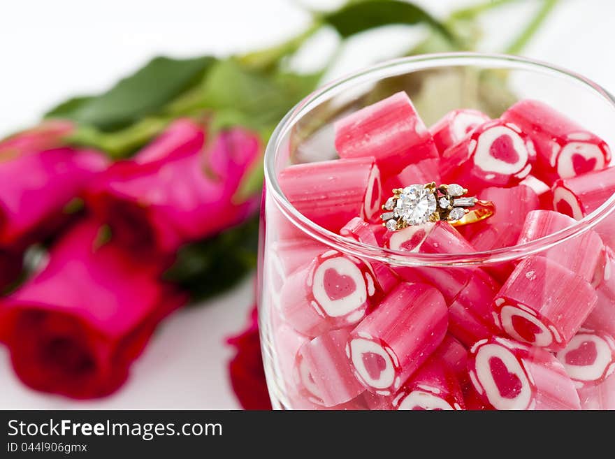 Valentine Series, Diamond Ring and Candy in wine glass on white background