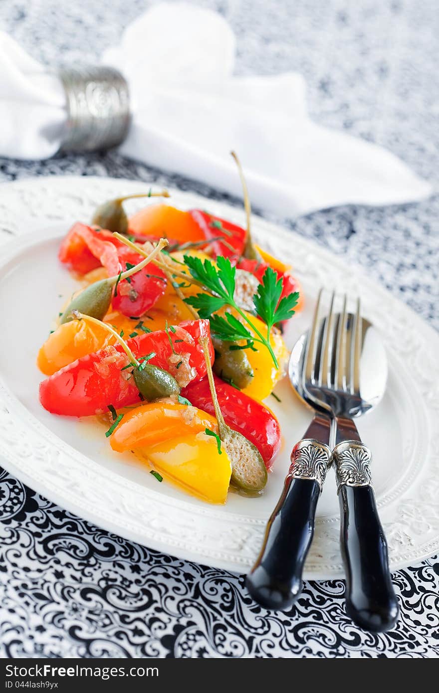 Italian stewed peppers with capers and anchovies, selective focus. Italian stewed peppers with capers and anchovies, selective focus