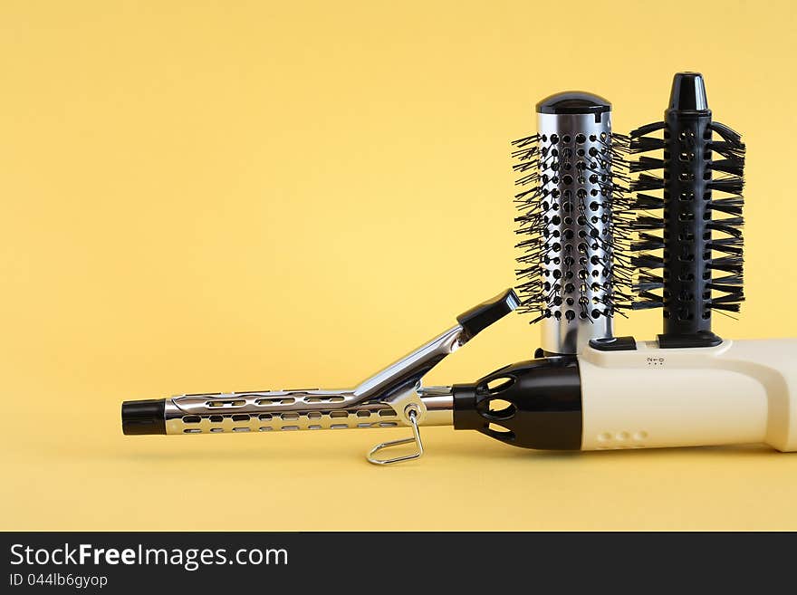 Hairdressing set with various accessories on yellow background