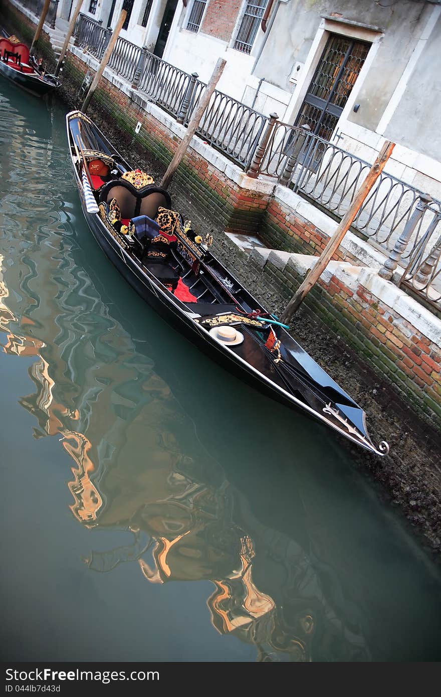 Urban scene in Venice, Italy. Empty gondola near dwelling house on a canal. Urban scene in Venice, Italy. Empty gondola near dwelling house on a canal