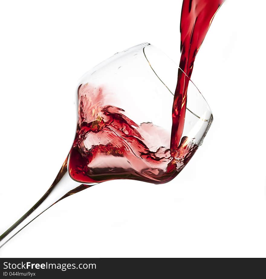 Red wine pouring into glass, isolated on white background