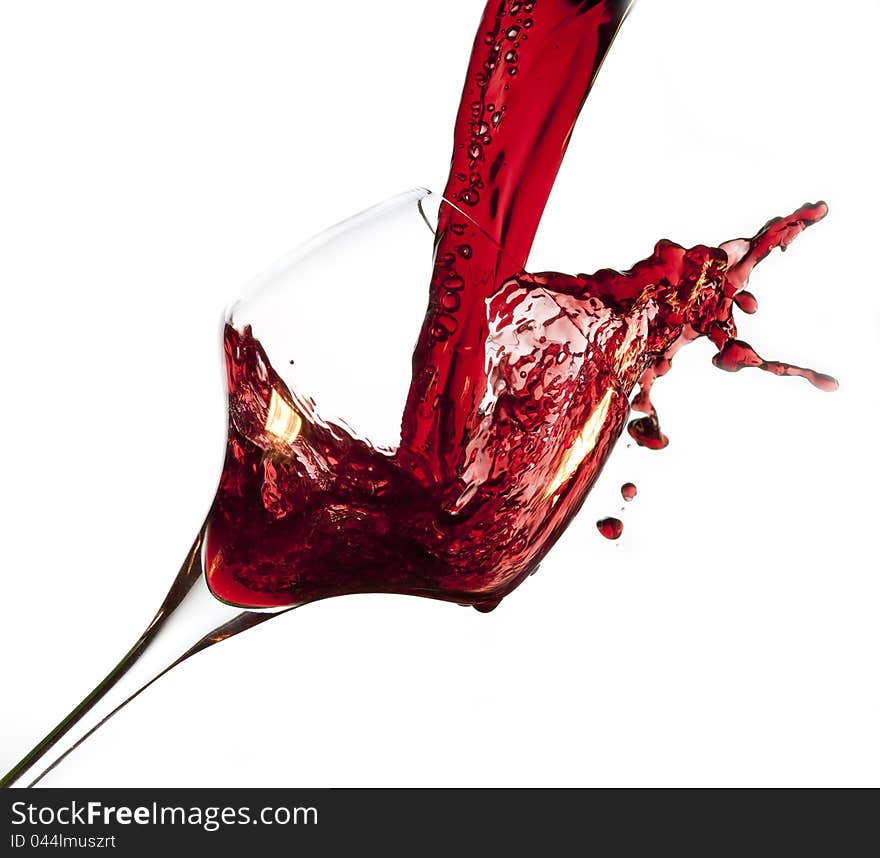 Red wine pouring into glass, isolated on white background