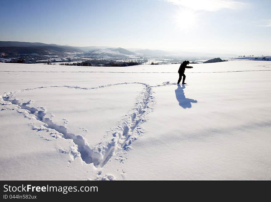 Man making big heart sign in snow