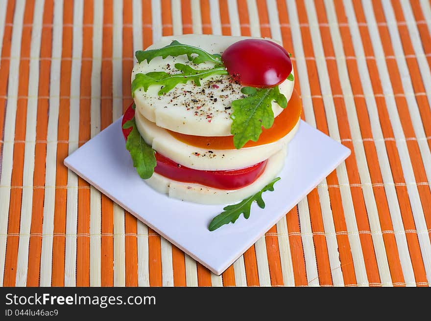 A light snack of cheese, tomato, and rocket salad. A light snack of cheese, tomato, and rocket salad