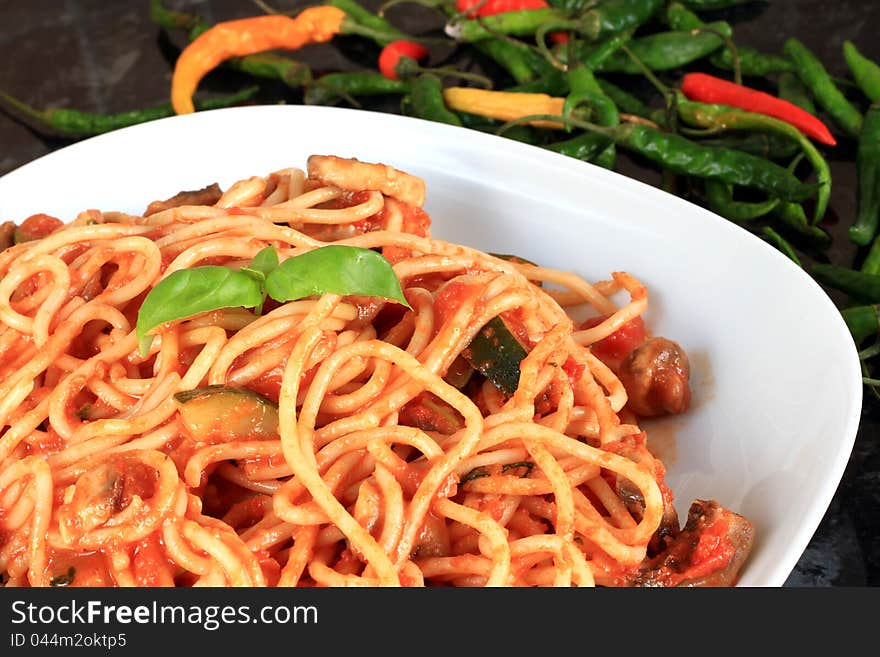 Image of a plate of spaghetti with tomato sauce and chilli peppers. Image of a plate of spaghetti with tomato sauce and chilli peppers