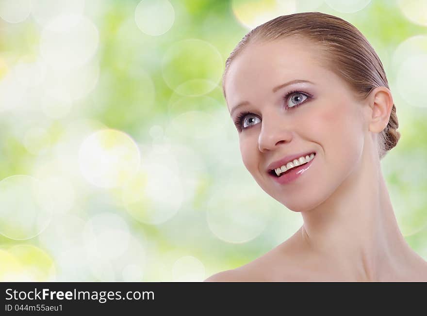 Beautiful face of a healthy young woman on a green background