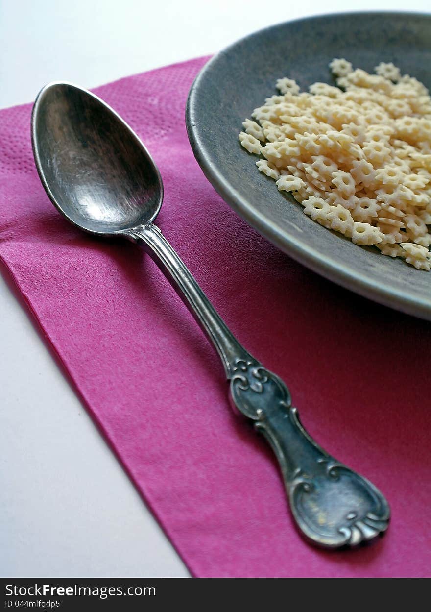 Old retro spoon with plate and pasta