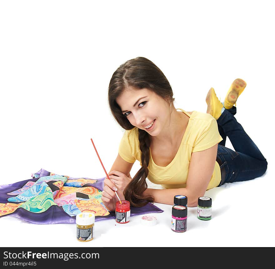 Woman lying in the studio and draws with colored paint on fabric, isolated on white. Woman lying in the studio and draws with colored paint on fabric, isolated on white