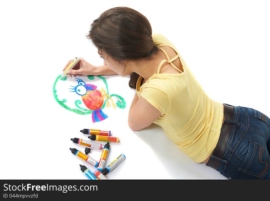 Portrait of cute young woman lying in the studio and draws with colored paint on fabric, isolated. Portrait of cute young woman lying in the studio and draws with colored paint on fabric, isolated