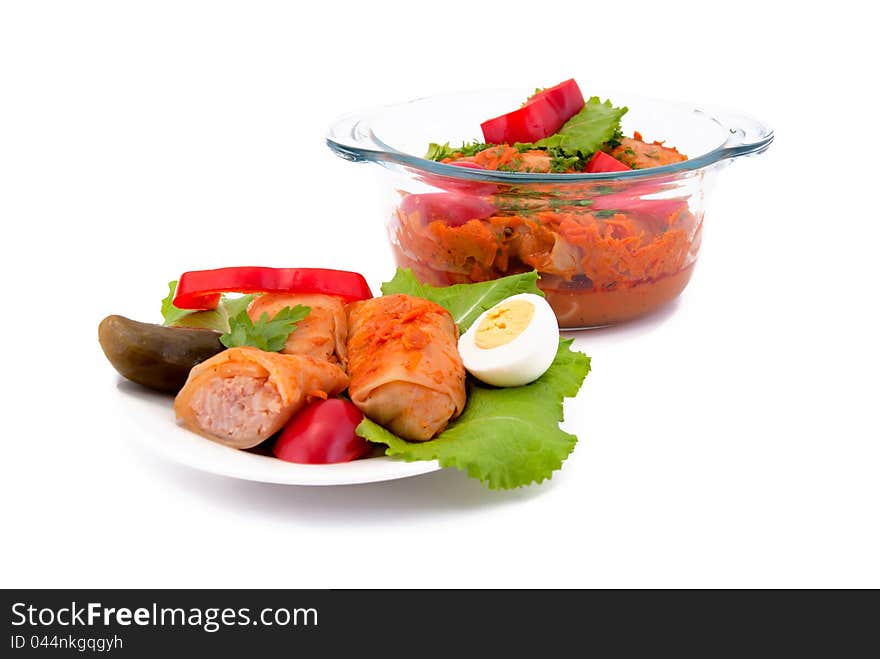 Stuffed cabbage on plate and in a pan, isolated on white