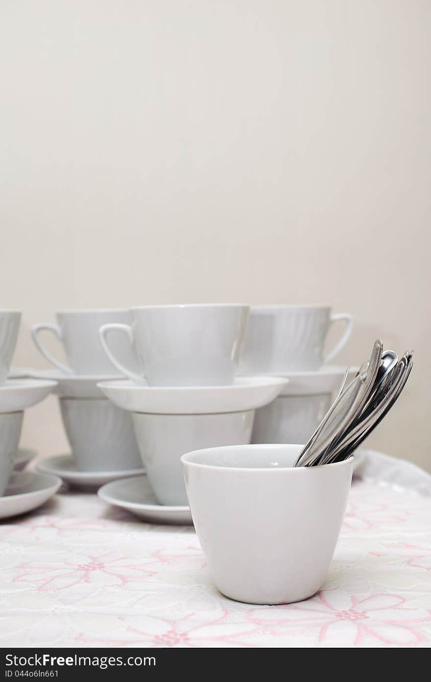 Many white cups with spoon on a table