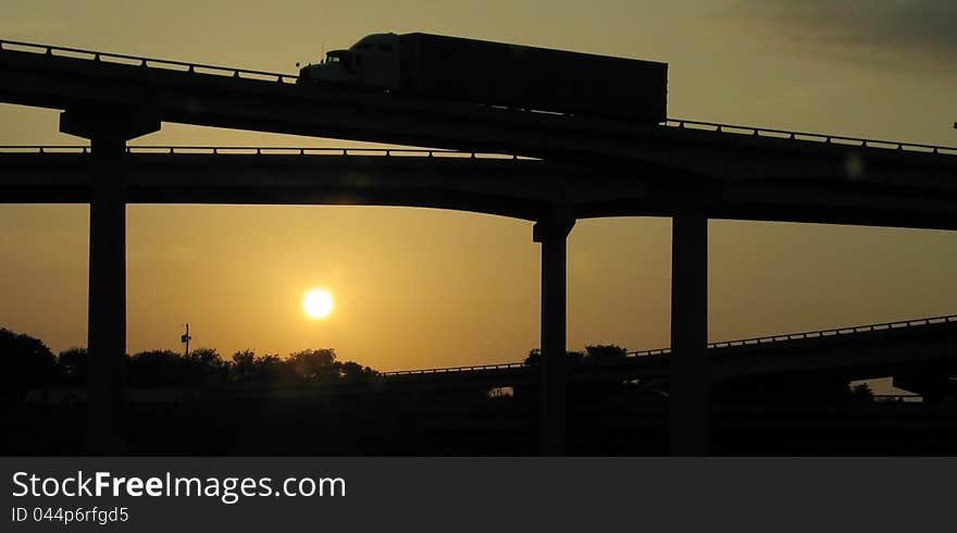 Truck goes over the bridge against the backdrop of the evening setting sun. Truck goes over the bridge against the backdrop of the evening setting sun