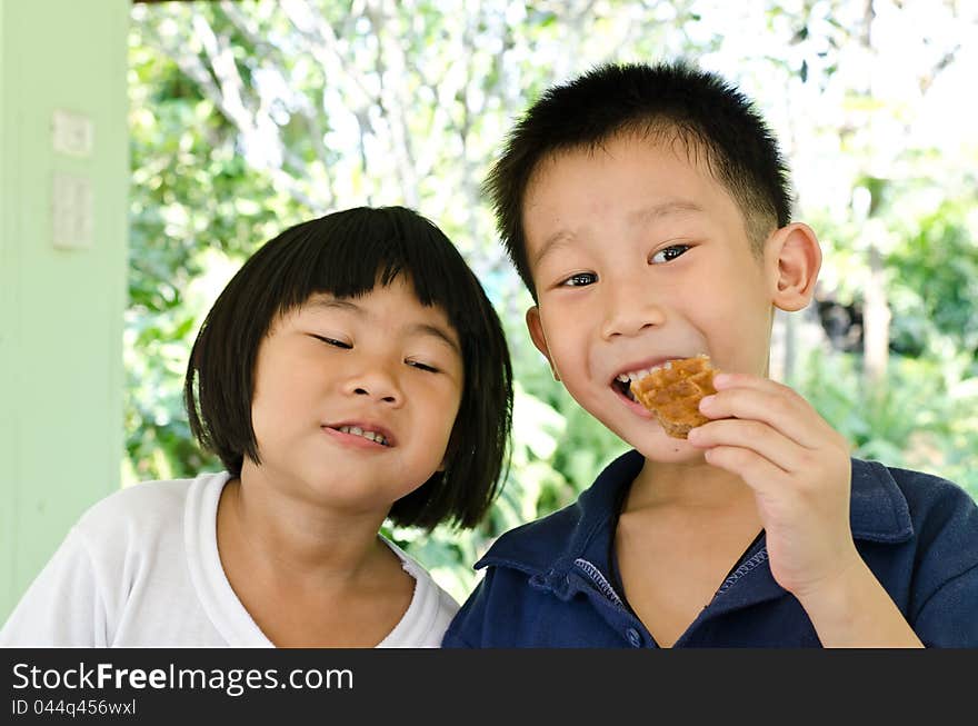 Happy Asian brother and sister enjoy muffin