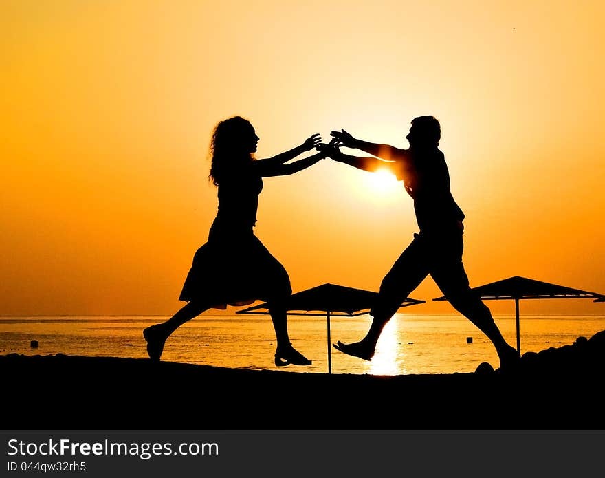 Male and female at sunrise at beach