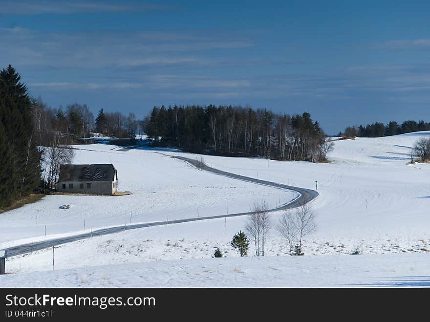 House in winter with forest, snow and clouds