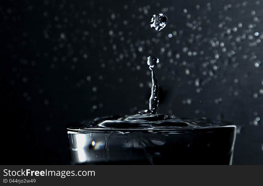 Falling waterdrop in a glass of water. Falling waterdrop in a glass of water