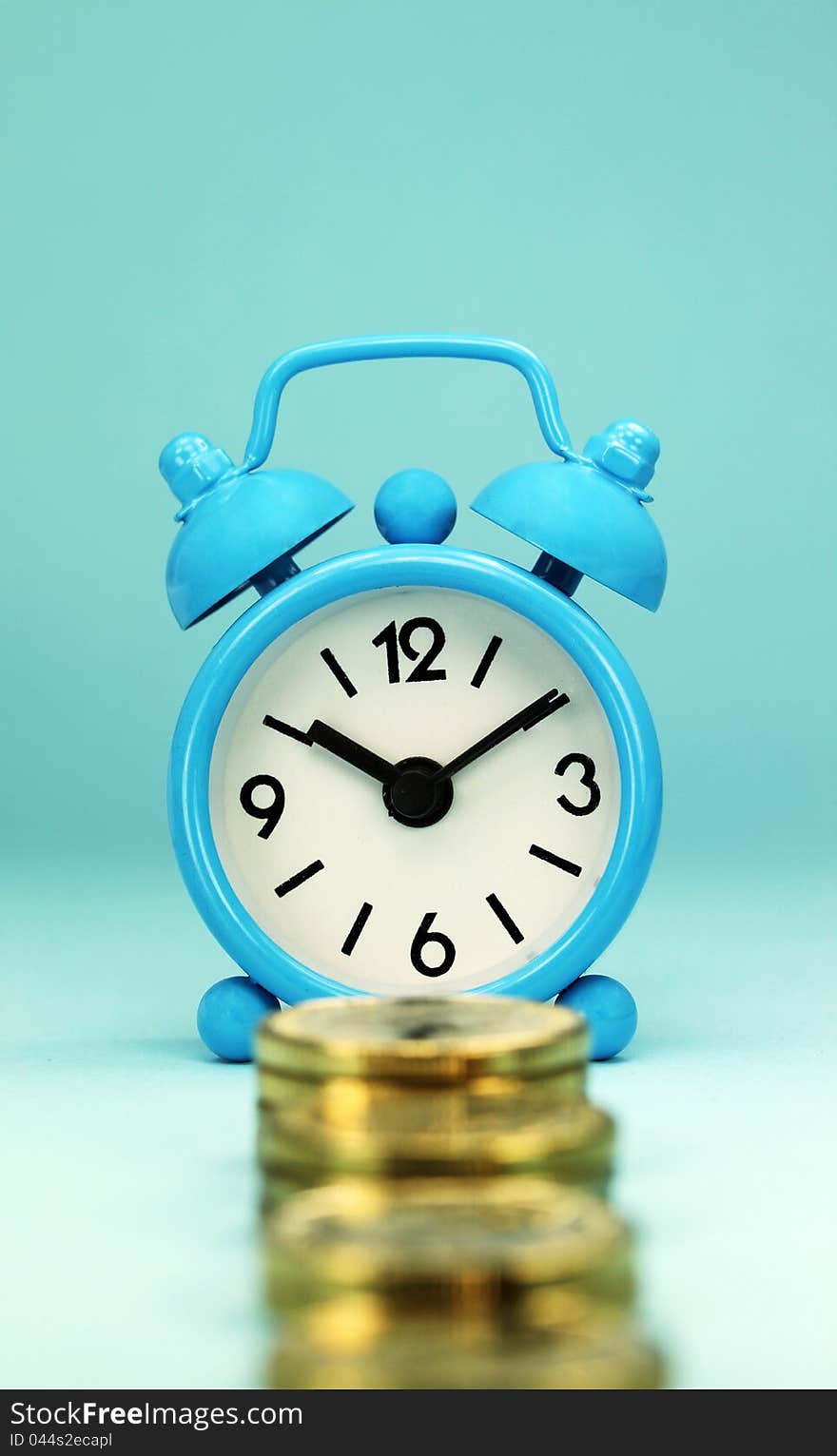 A light blue alarm clock with a stairway of gold coins in front it, signifying the longevity of a bank  loan. A light blue alarm clock with a stairway of gold coins in front it, signifying the longevity of a bank  loan.