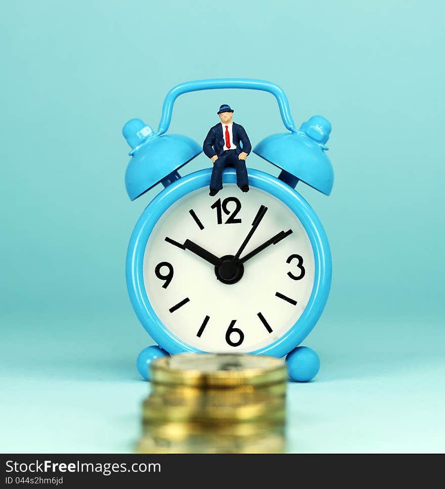 A bank manager sat on top of a light blue alarm clock, in front of a golden coin stairway,  asking the question, can you last the financial journey. A bank manager sat on top of a light blue alarm clock, in front of a golden coin stairway,  asking the question, can you last the financial journey