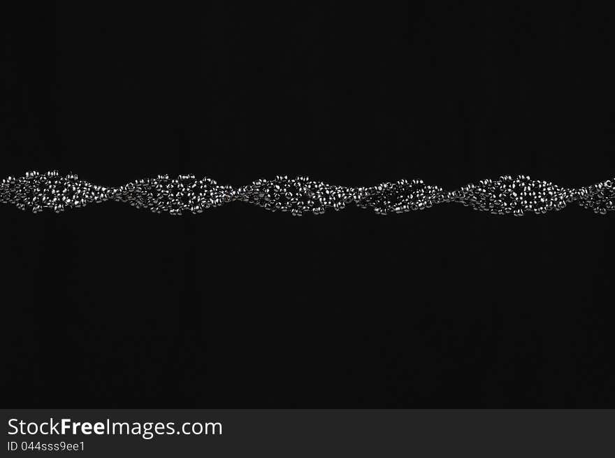 A handmade woven seed bead necklace on a black background