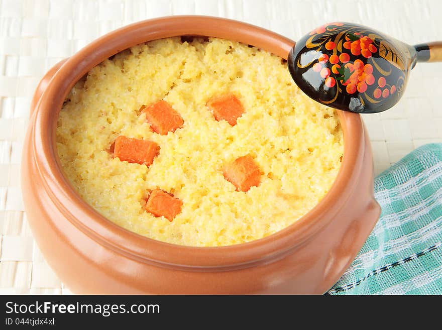 Dairy millet porridge with pumpkin in a ceramic pot