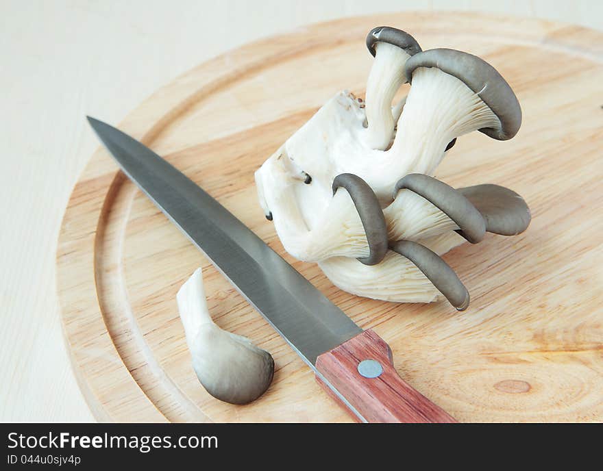 A bunch of oyster mushrooms and  knife