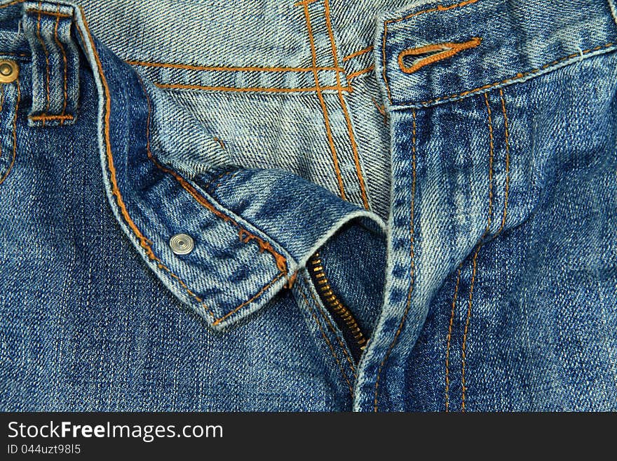 A close up image of a pair of unzipped blue jeans. A close up image of a pair of unzipped blue jeans