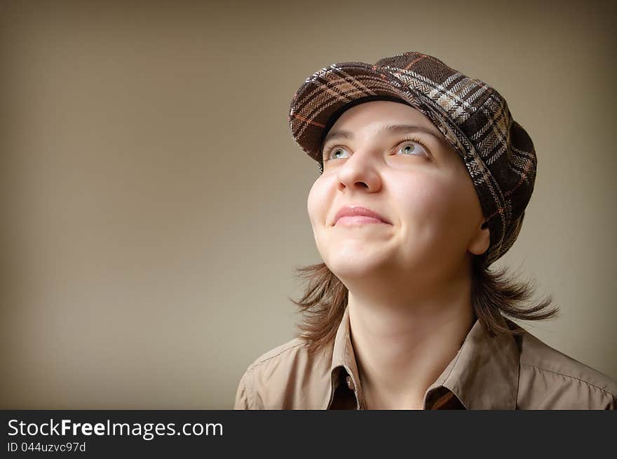 Portrait of a young woman smiling in checked cap. Portrait of a young woman smiling in checked cap