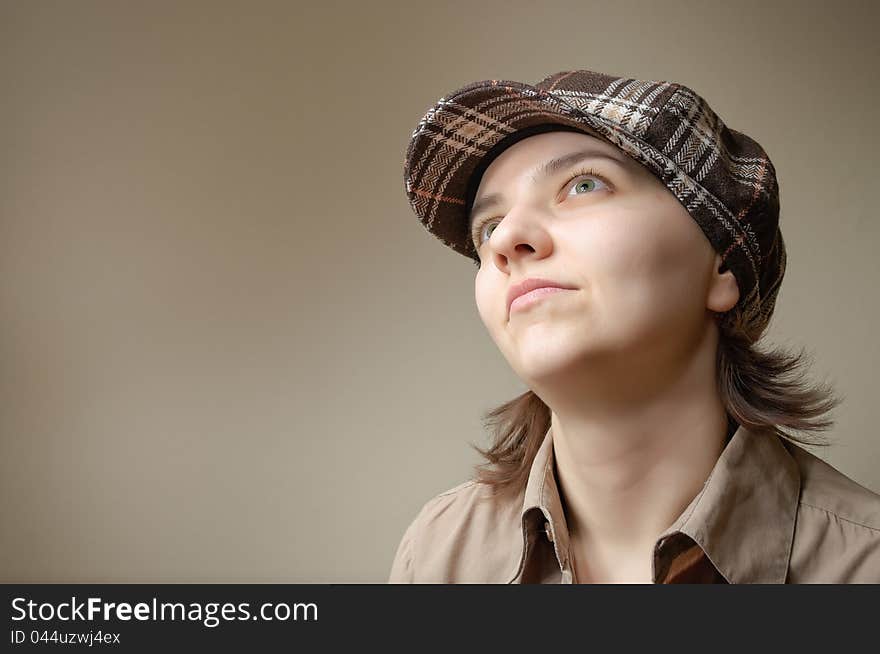 Young green eyed woman daydreaming in checked cap. Young green eyed woman daydreaming in checked cap