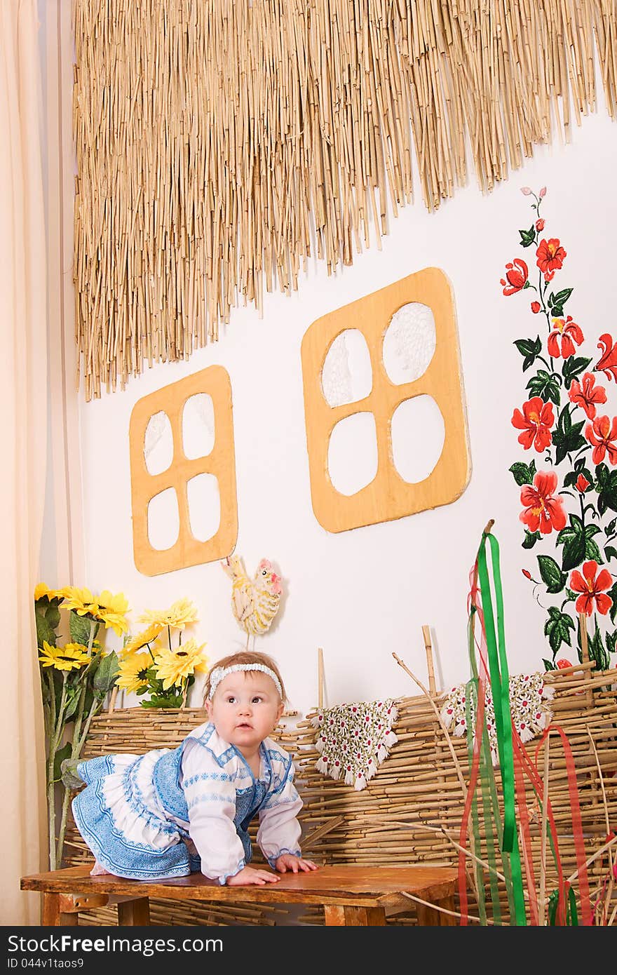 Children in Ukrainian national costume sitting on a bench under village house. Children in Ukrainian national costume sitting on a bench under village house