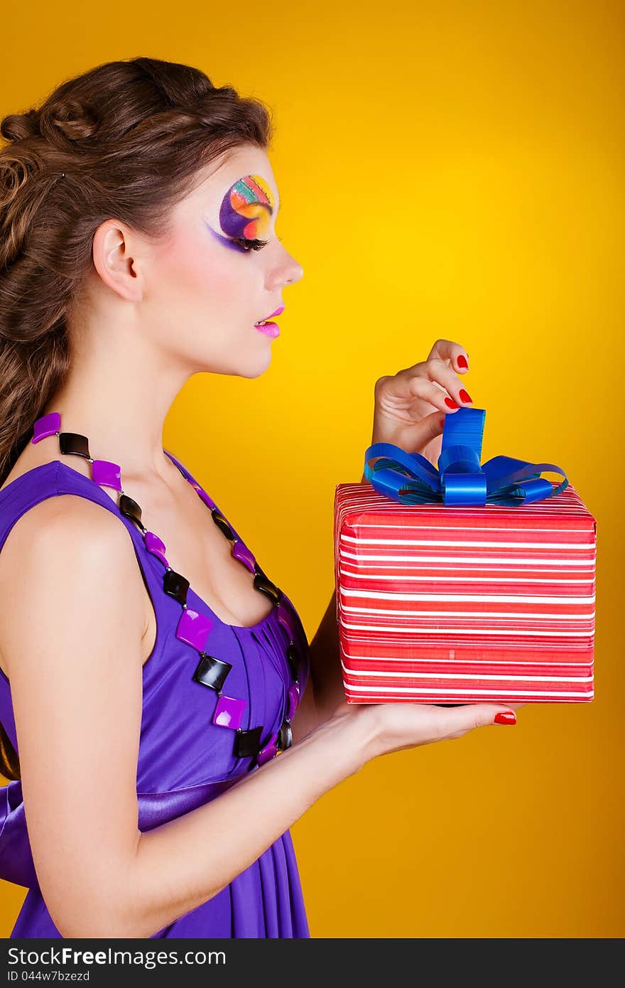 Young beautiful woman with make up is opening gift