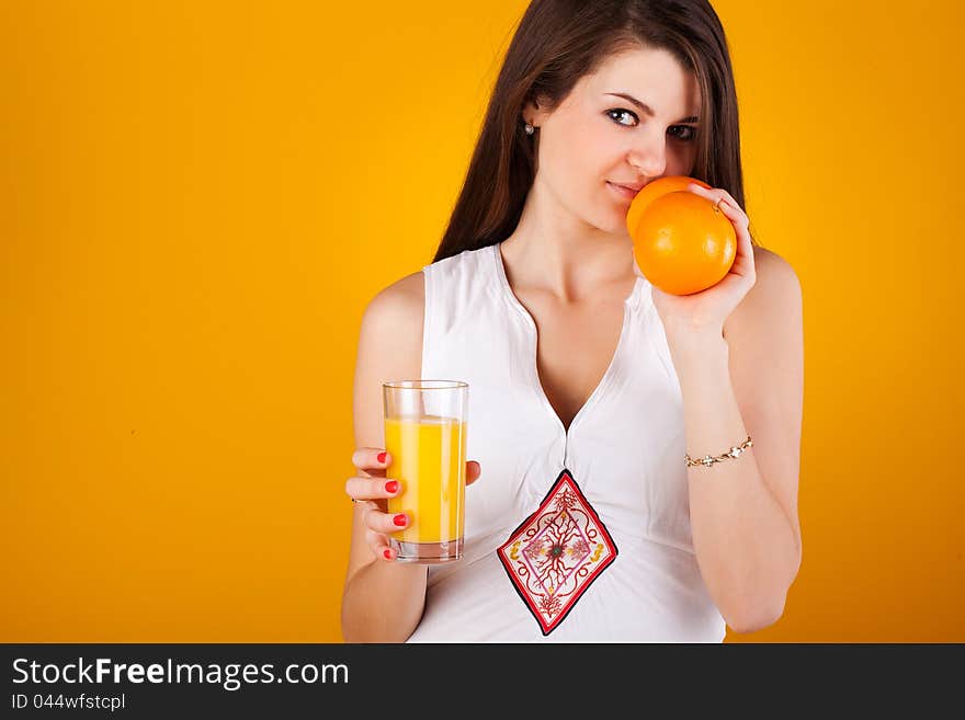 Pretty woman with juice an orange on yellow. Pretty woman with juice an orange on yellow