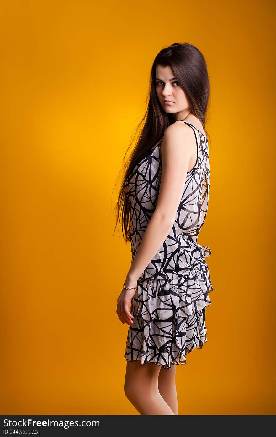 Young woman in dress on yellow background