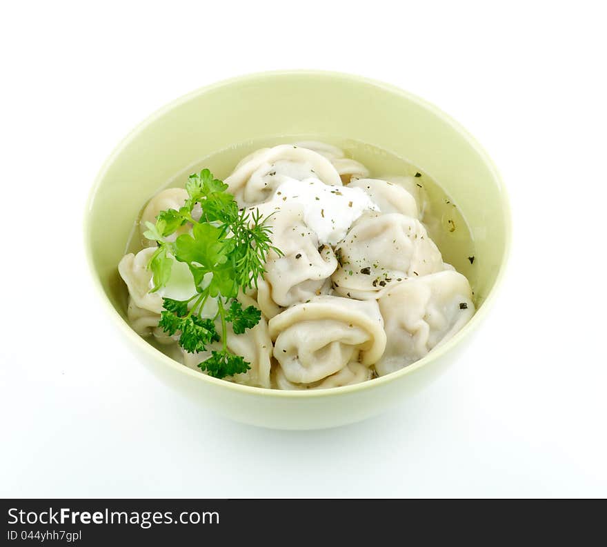 Meat pelmeni with sour cream and greens isolated on white background