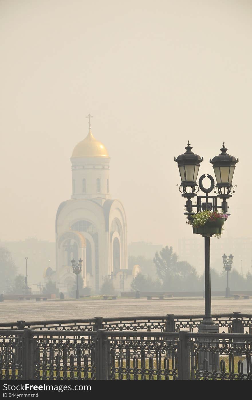 Street lantern on a background a church is in morning haze