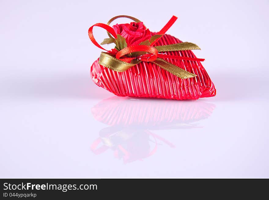 A heart shaped red gift on white. A heart shaped red gift on white