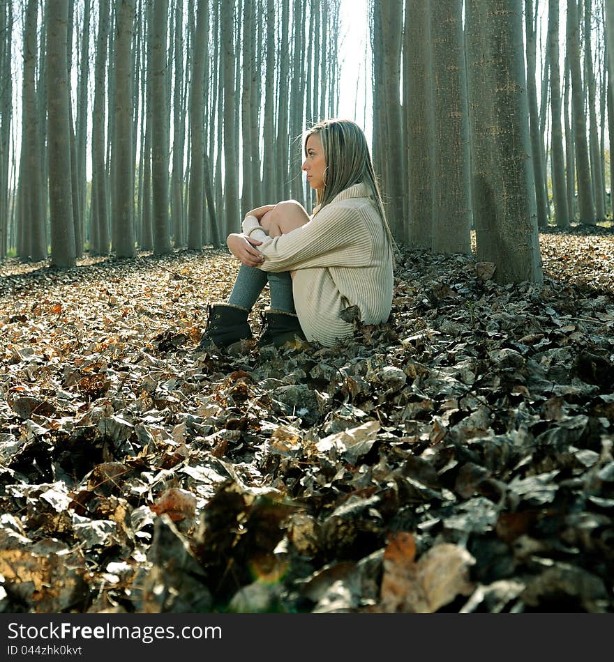 Beautiful blonde girl thinking in the woods